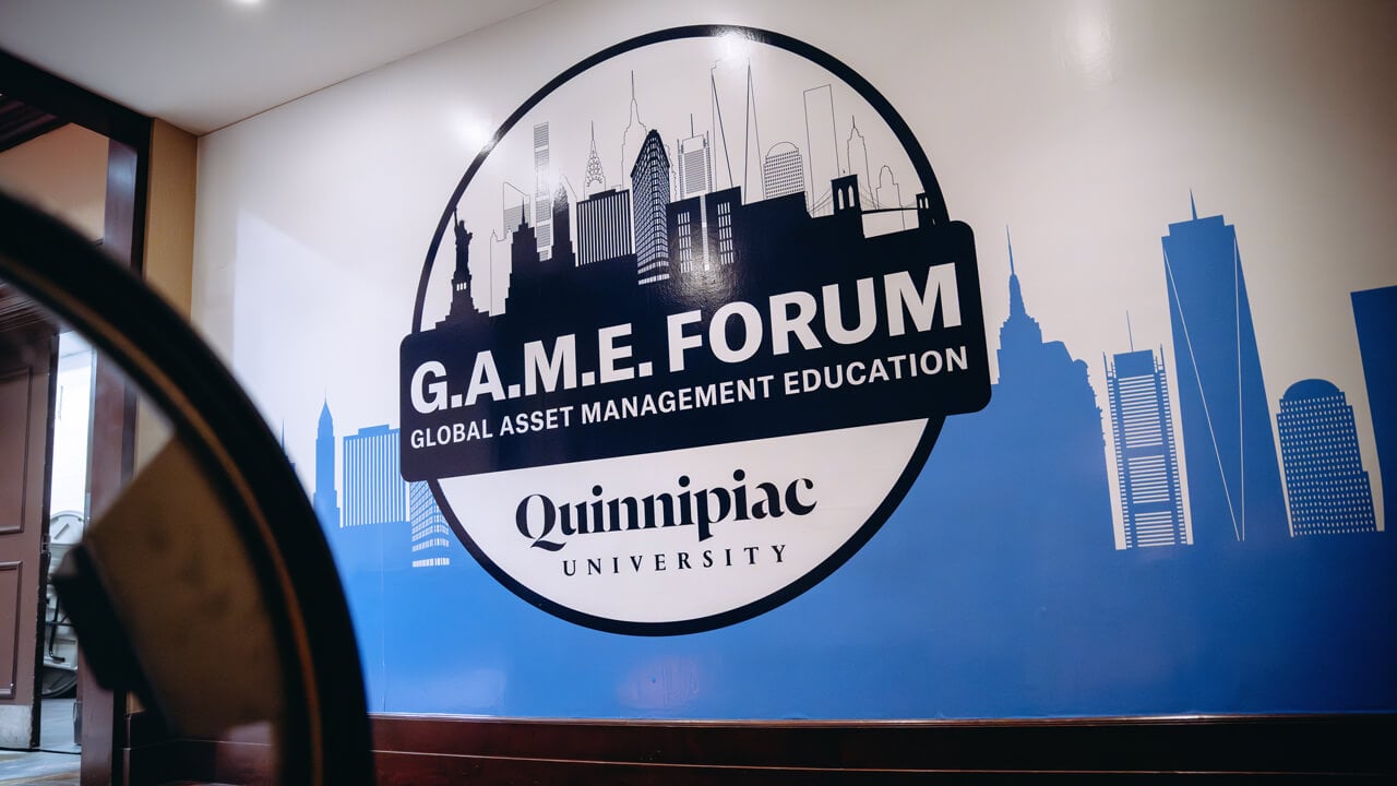 Quinnipiac Global Asset Management Education GAME Forum logo on a wall