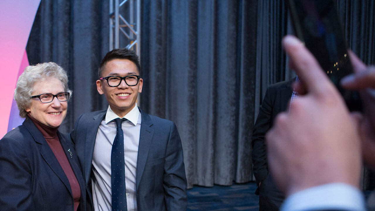 A student poses with a presenter for a photo during GAME Forum
