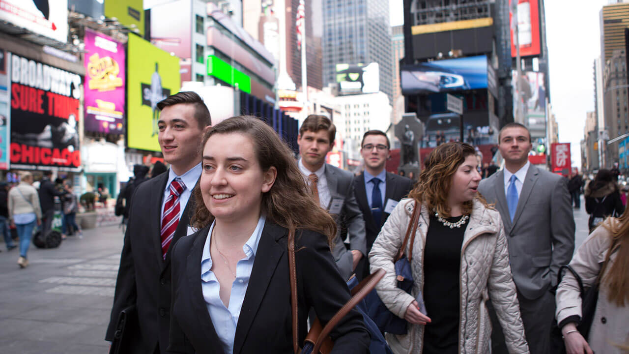 Half a dozen students walk through Times Square in New York City