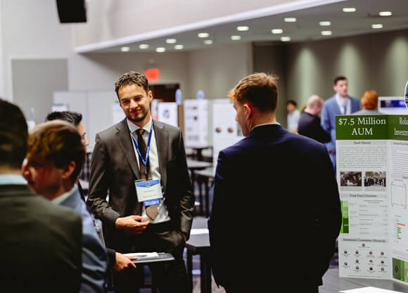 Financial experts and students converge for a networking event, where guests network with peers and evaluate student poster presentations during the Forum.