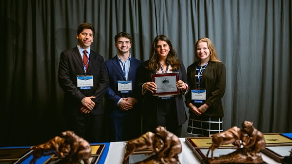 Student participants in the Graduate Overall category gather on stage with their award at the Forum Awards Ceremony.