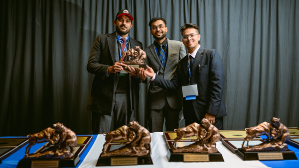 The Washington University portfolio winners pose with their award statue.