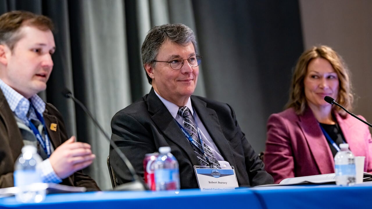 Hunter Holzhauer, Robert Burney, and Kimberly McGinnis seated at a panel table during a Forum panel.