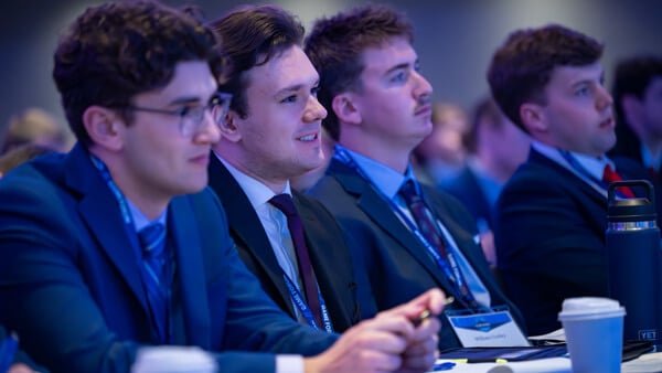 A row of Forum attendees listen eagerly to a panel.