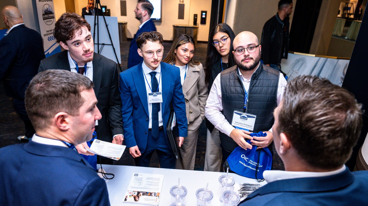 Students gather closely to listen to UBS professionals discuss career tracks and firm values.