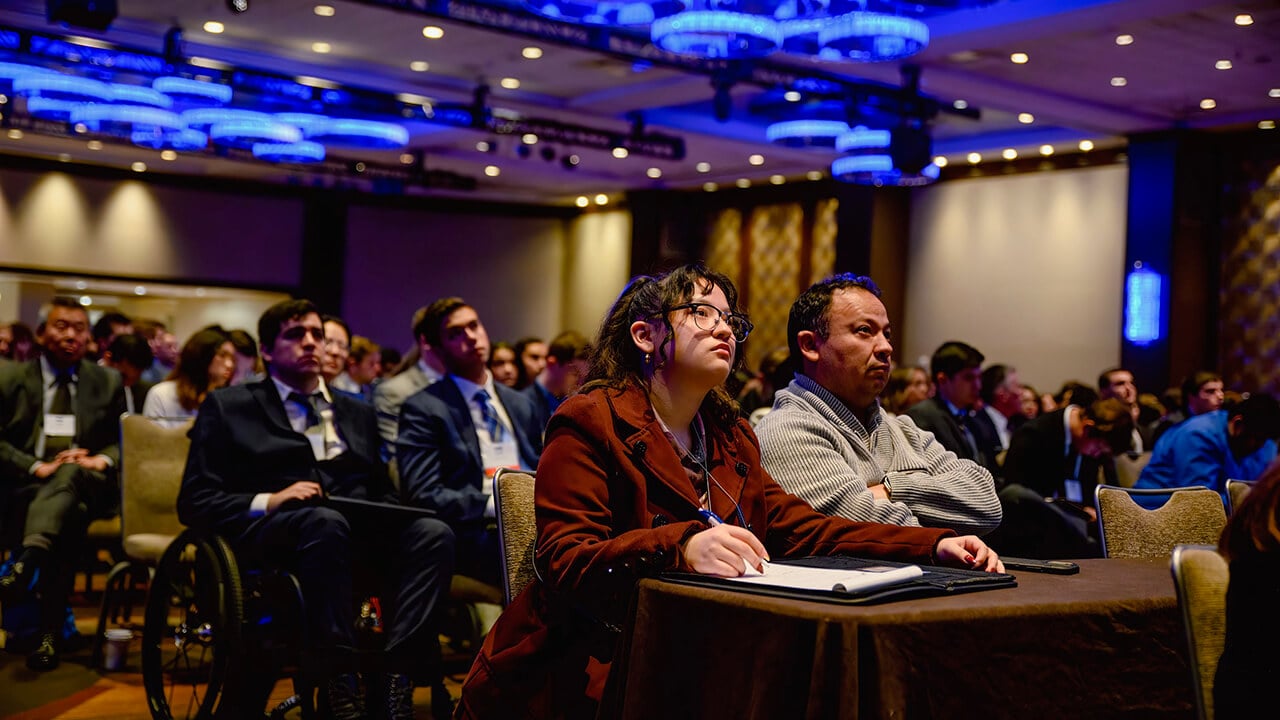 Crowd listening to a speaker at student run financial conference