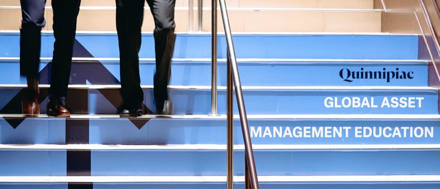 Students in professional attire walking down GAME Forum branded stairs.